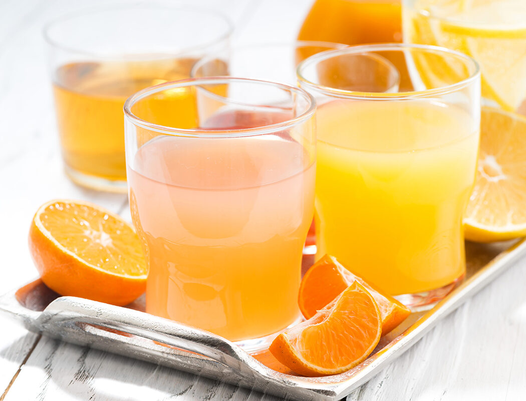 fresh citrus juices in assortment, closeup, horizontal